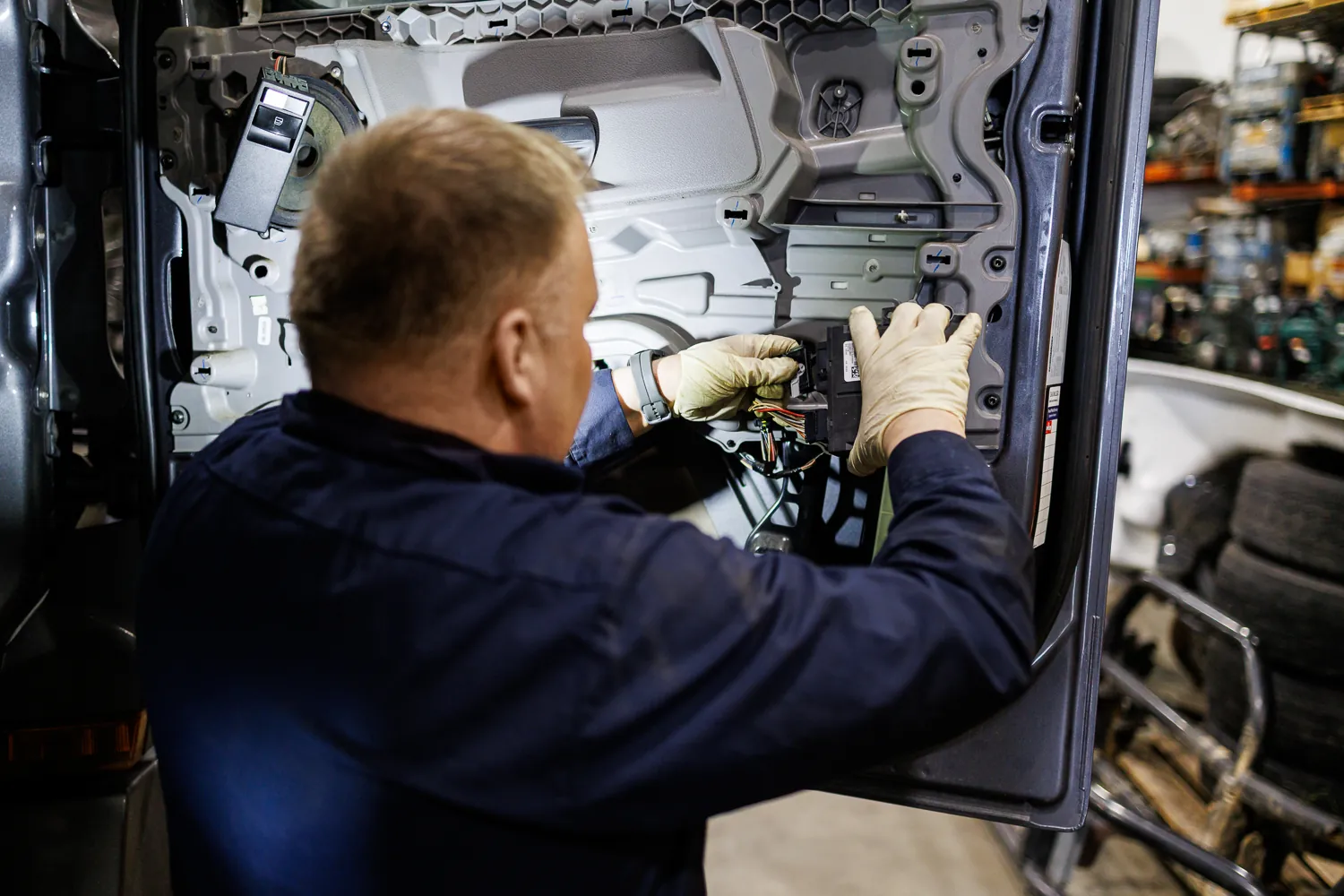 Technician working on the wiring inside an exposed truck door