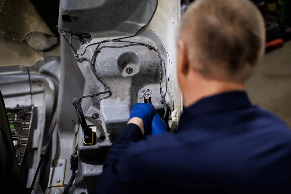 Two technicians diagnosing a truck engine at Truck Clinic in Romeoville, one with a laptop on the engine