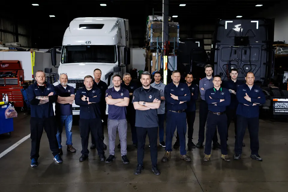 Truck Clinic technicians standing with a truck in the Romeoville workshop
