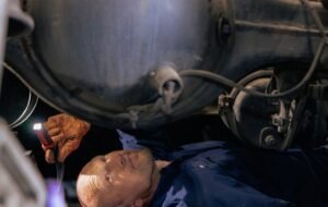 man under the car doing truck repair inspection