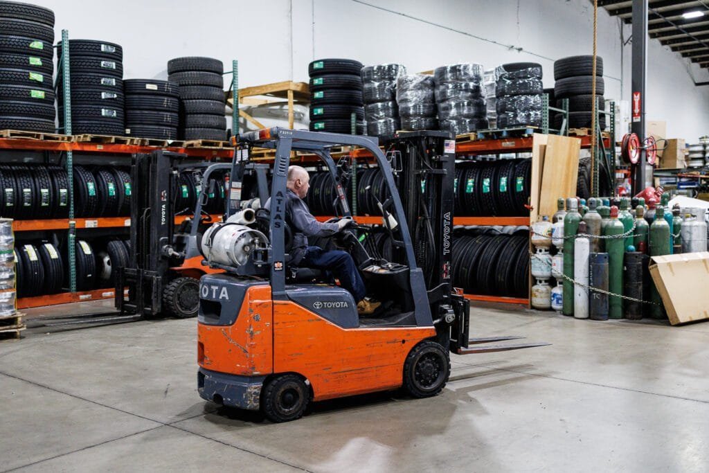 man working with a mobile lifter in truck repair shop